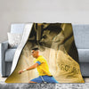 A large print featuring a portrait of Ronaldinho in a yellow shirt and blue shorts on a blanket.