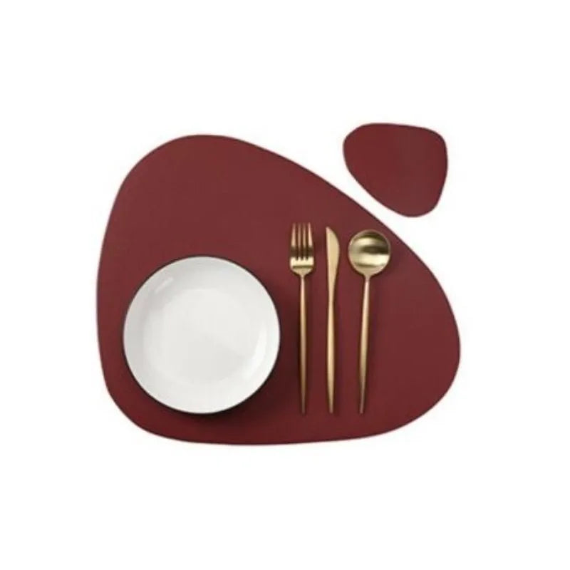 A set of reusable vinyl placemats featuring a deep maroon color and gold cutlery on a white plate.