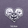 White embroidered heart-shaped skull patch with the words Love and Life on a gray background