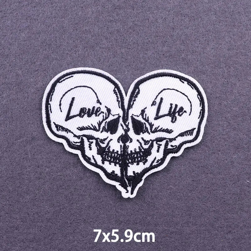 White embroidered heart-shaped skull patch with the words Love and Life on a gray background