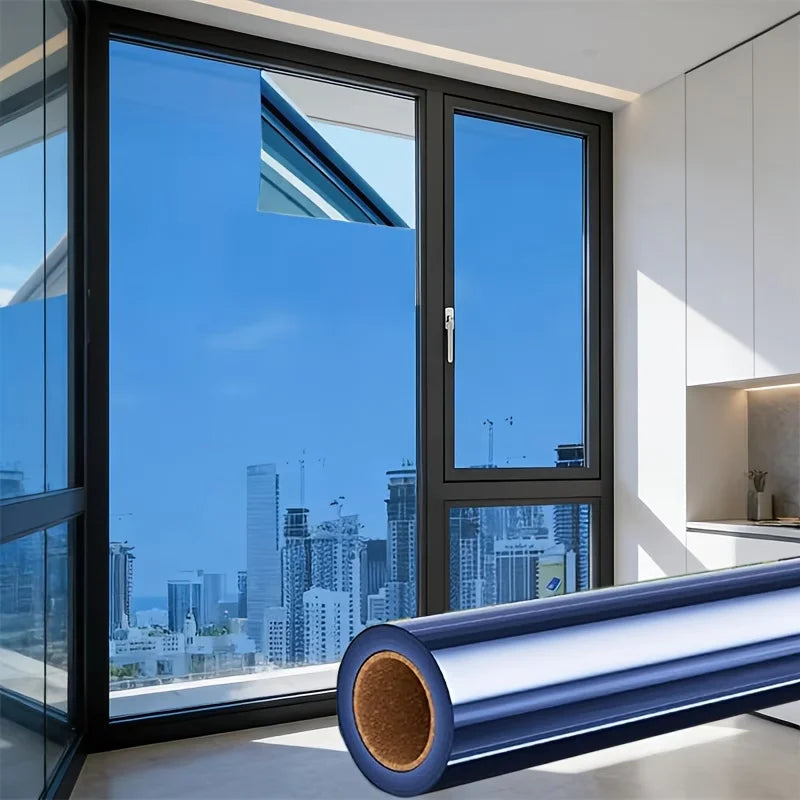A large window with a reflective mirror film installed, showing an urban skyline and bright blue sky.