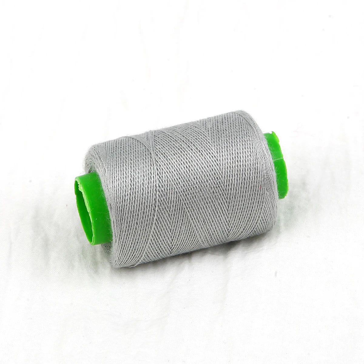 A roll of gray sewing thread with a bright green core.