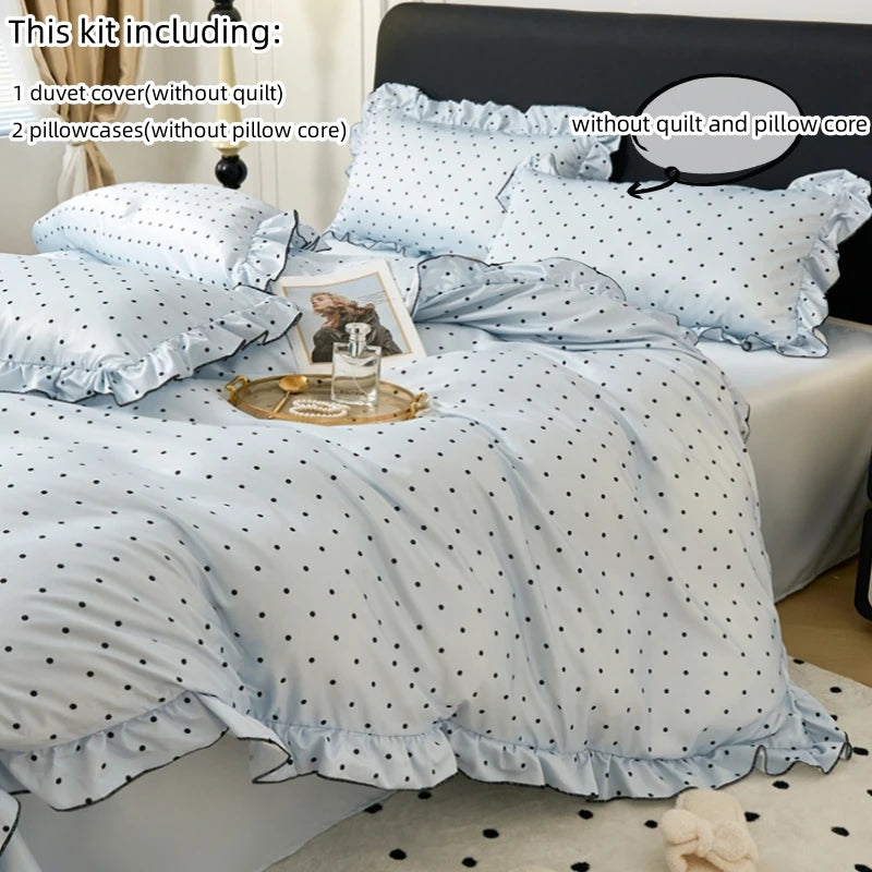 A set of light blue polka dot duvet cover, pillowcases, and decorative pillows displayed on a bed.