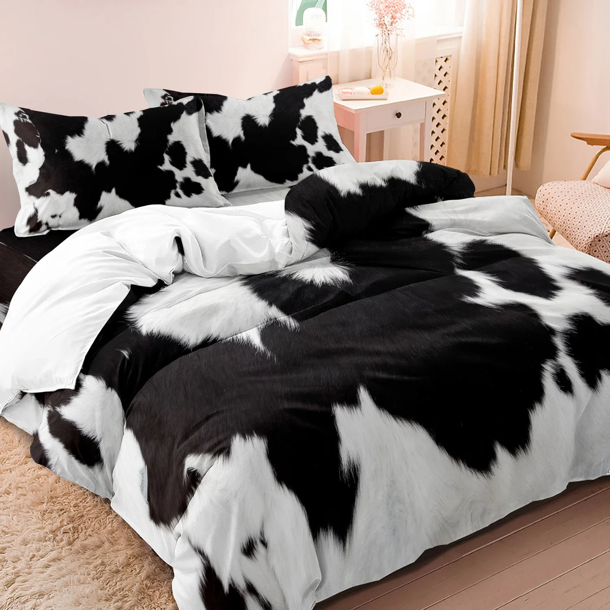 Black and white cow print yak leather duvet cover set displayed on a bed.