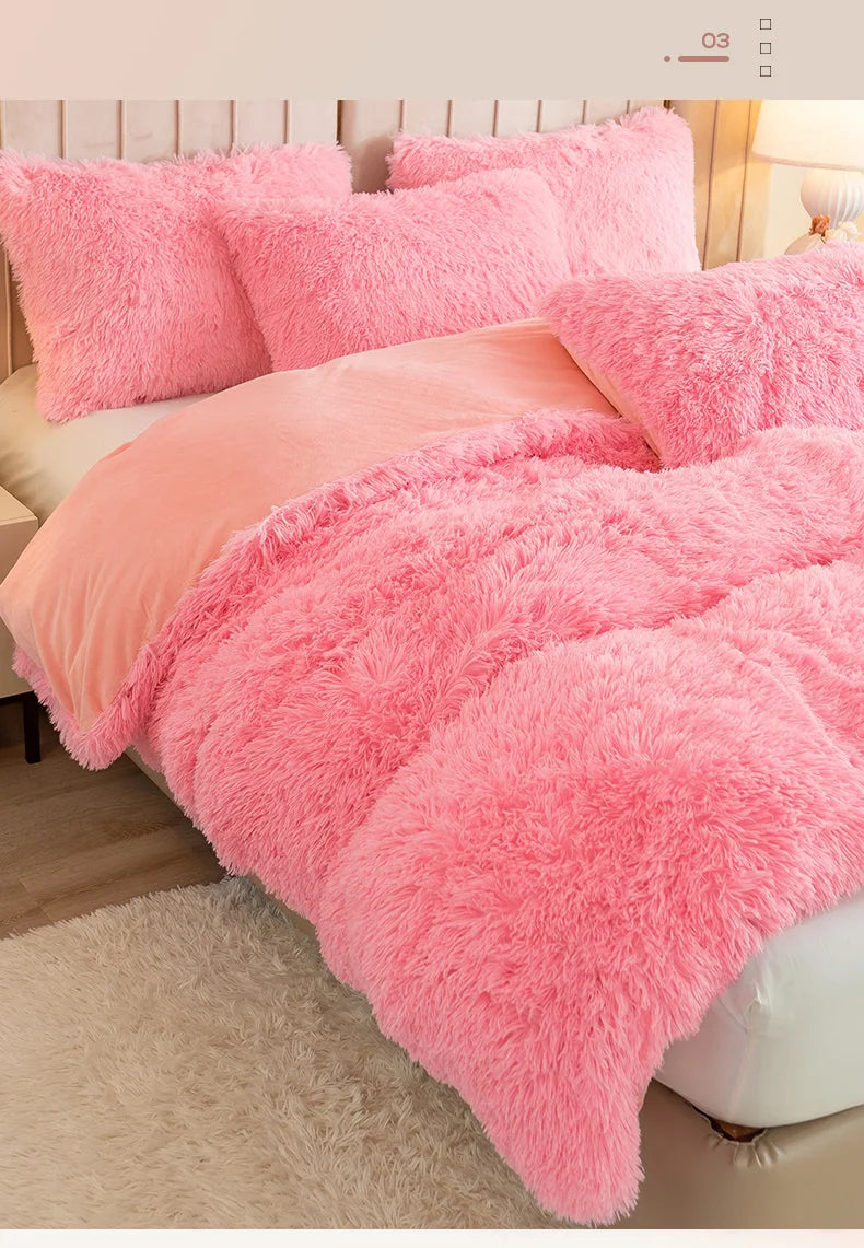 A pink plush duvet cover set with a matching pink fluffy blanket and pillows on a bed.