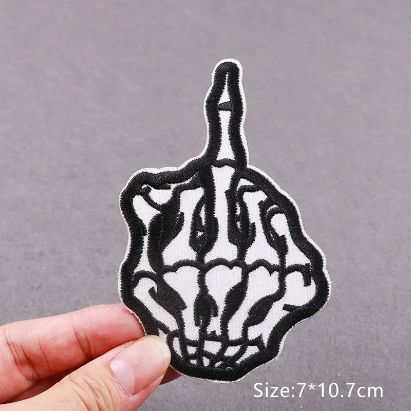 Black and white embroidered patch depicting a hand with long, sharp fingers.
