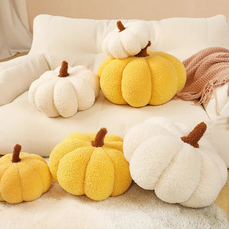 A collection of yellow and white plush pumpkin throw pillows resting on a light-colored sofa.