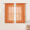 Orange pompom jacquard sheer curtain hanging in a window frame