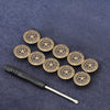 A set of ten round, antique brass metal snap buttons arranged in a line on a dark blue fabric.