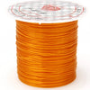 A spool of bright orange multicolor elastic beading cord with a white and red patterned label.