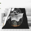A black throw blanket featuring a silhouette of a bat-like creature and a gothic building against a moonlit background.