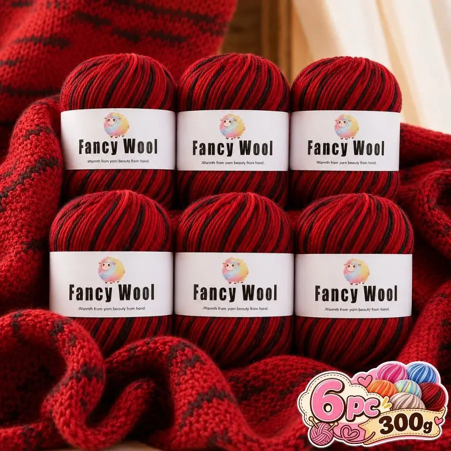 A set of six red wool yarn skeins labeled Fancy Wool stacked on a red knitted fabric.