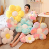 A collection of yellow and pink fluffy sunflower plush flowers arranged on a wooden floor.