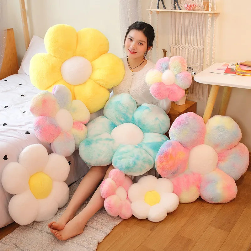 A collection of yellow and pink fluffy sunflower plush flowers arranged on a wooden floor.
