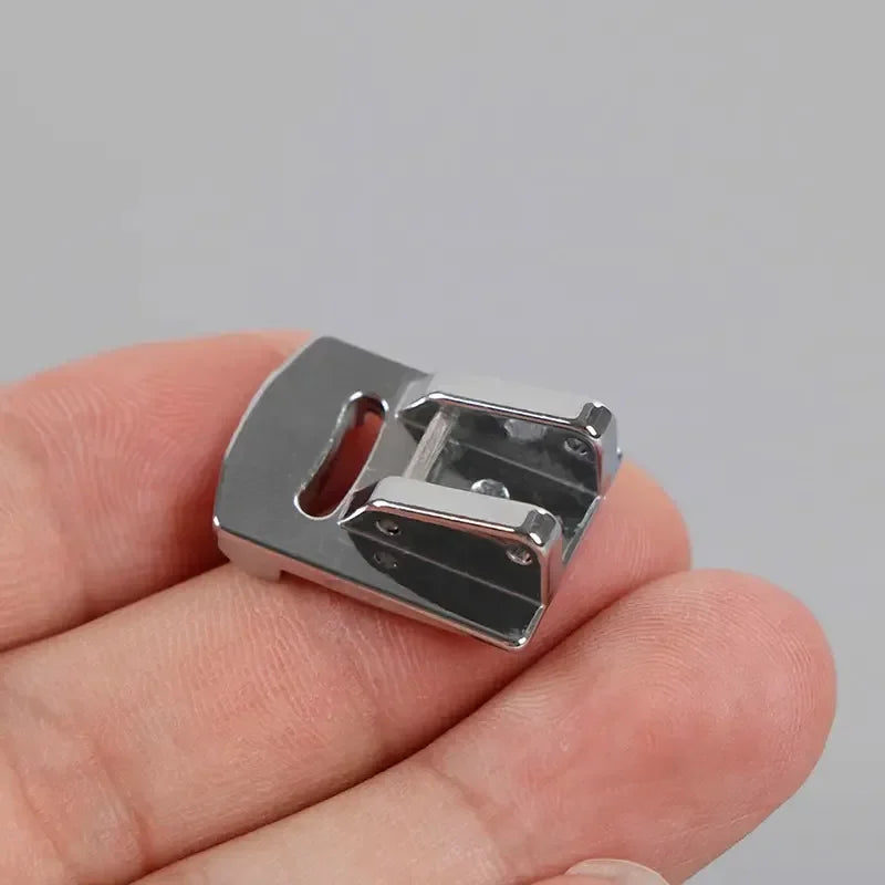 A close-up of two stainless steel rolled hem feet for sewing machines held in a person's hand.