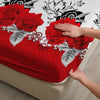 A hand gently touches a vibrant red rose pattern on a fitted mattress cover.