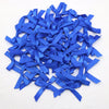A pile of small royal blue satin ribbon bows for crafts and decor.