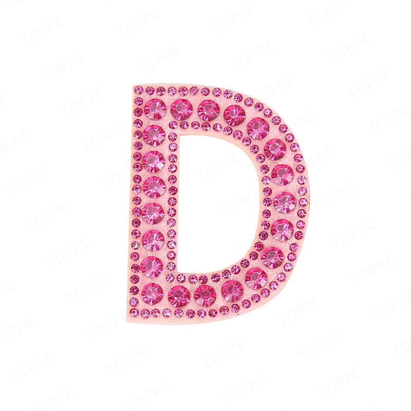 A pink rhinestone letter D patch used for DIY projects.