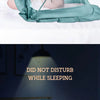 A close-up of a teal foldable mosquito net covering an infant sleeping in a crib.