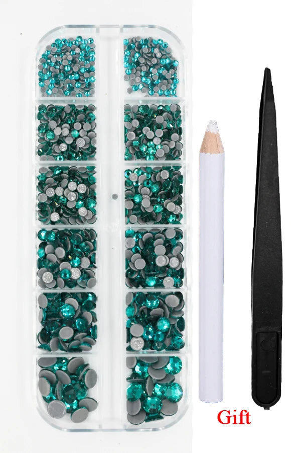 A clear plastic case containing a set of green and blue crystal hot fix rhinestones with an applicator tool.
