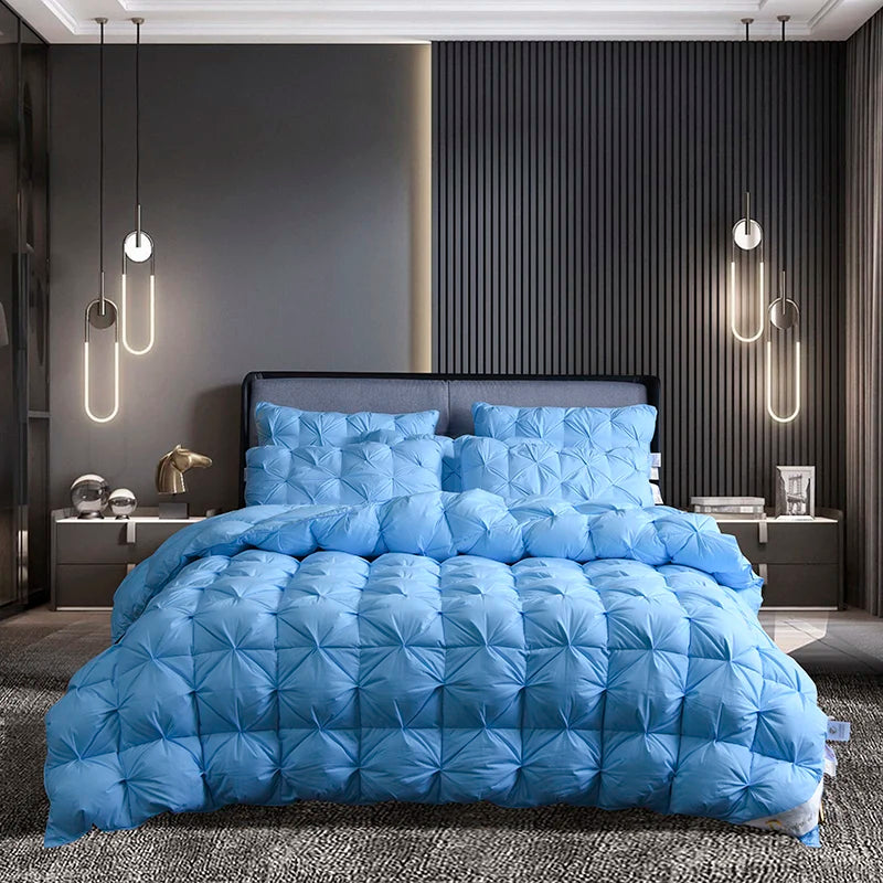 A light blue luxury goose down duvet blanket is displayed on a bed in a modern bedroom setting.