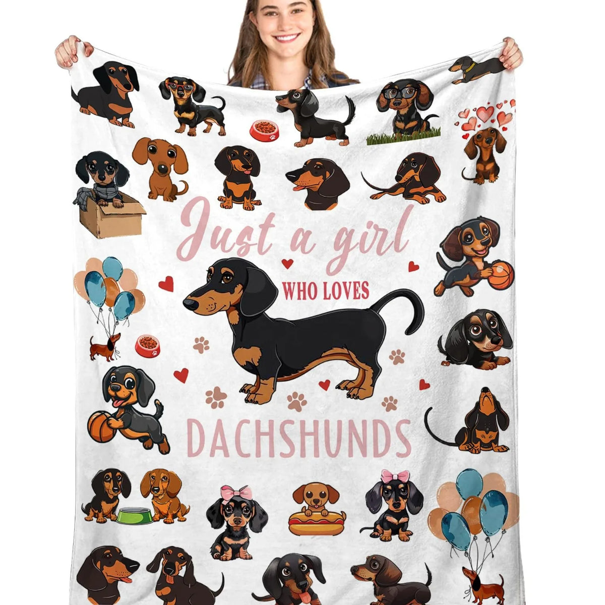 A woman is holding a pink flannel blanket featuring various dachshund illustrations.