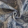 A dark blue and silver patterned fabric, likely a non-slip quilted sofa cover, is folded and draped.