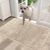 A light beige extra dense chenille pet door mat placed on a wooden floor near a white door frame.