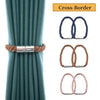 Close-up of a teal curtain with magnetic cross-border tieback clips in blue and brown colors
