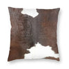 A square cushion cover featuring a brown and white faux fur cowhide print.