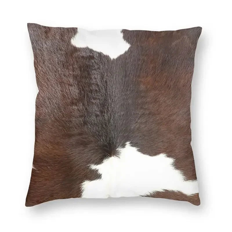 A square cushion cover featuring a brown and white faux fur cowhide print.