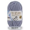 A ball of gray milk cotton yarn with a label indicating the product name and fiber content.