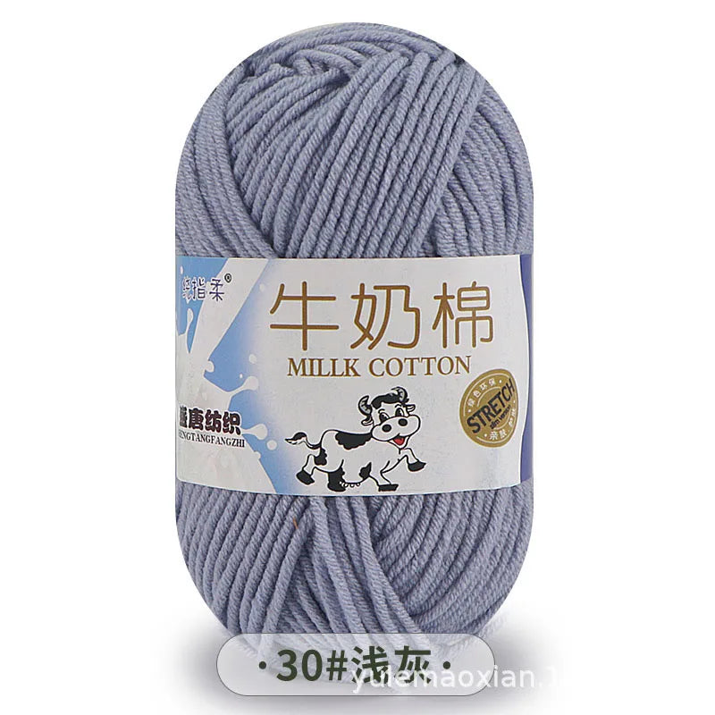 A ball of gray milk cotton yarn with a label indicating the product name and fiber content.