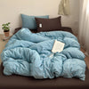 A blue and white striped cotton duvet cover set with a dark brown pillow on a bed.