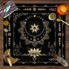 A dark mat featuring a celestial design with floral elements, including crystals, and an orange candle.