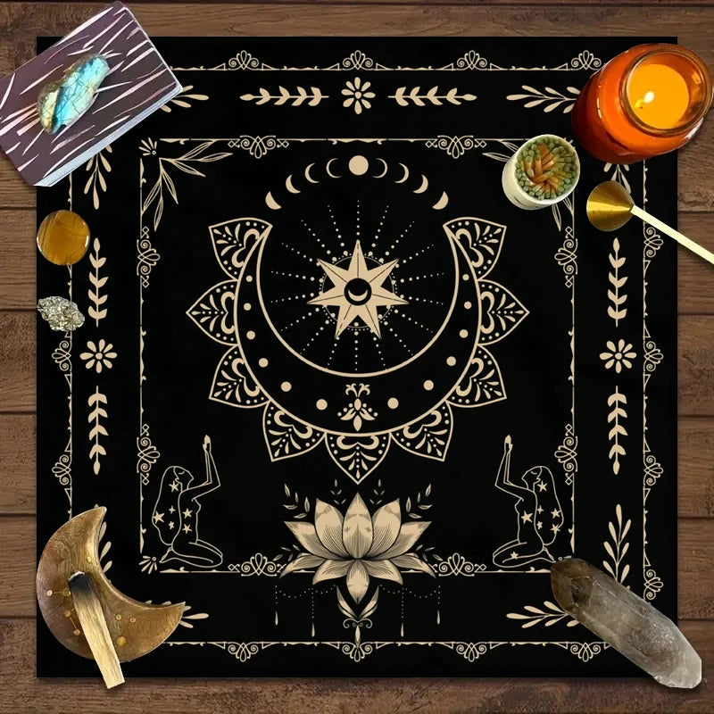 A dark mat featuring a celestial design with floral elements, including crystals, and an orange candle.