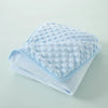 A soft light blue fleece swaddle blanket with a dimpled texture folded neatly on a light surface.