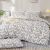 A heart print duvet cover set featuring gray and white hearts on a bed with white pillows.