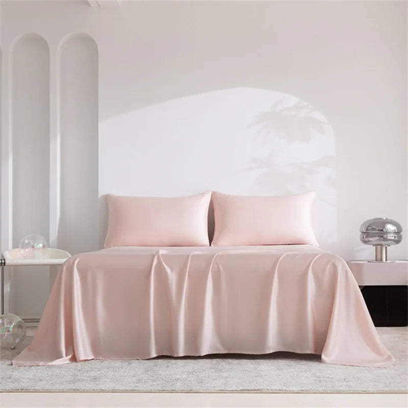 A pink luxury organic bamboo bed sheet set draped on a bed with white architectural details.
