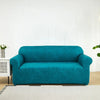 A teal blue PU leather sofa slipcover placed on a light rug in a bright room.