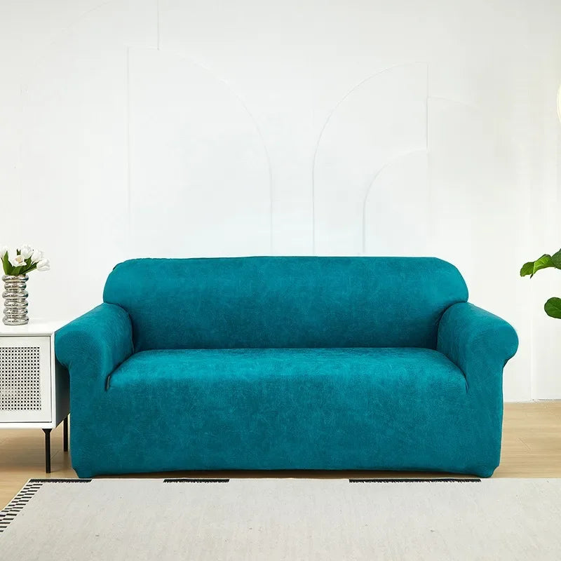 A teal blue PU leather sofa slipcover placed on a light rug in a bright room.