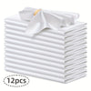A stack of twelve white silky satin dinner napkins with a decorative bow on top.