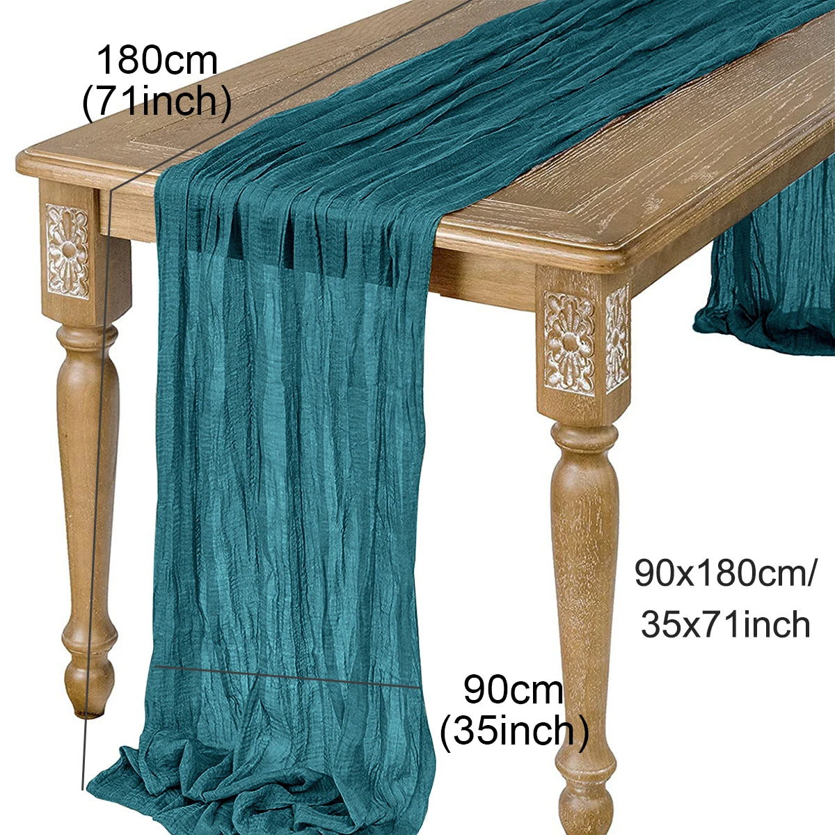 A teal semi-sheer gauze table runner draped over a wooden table, showing its length and texture.