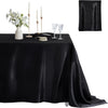 Black satin tablecloth set featuring candles, silverware, and a white floral arrangement for elegant dining decor