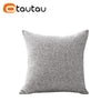 A square gray linen cushion cover with a button closure.