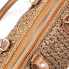 A close-up of a brown PU leather zipper frame attached to a handmade crochet bag.