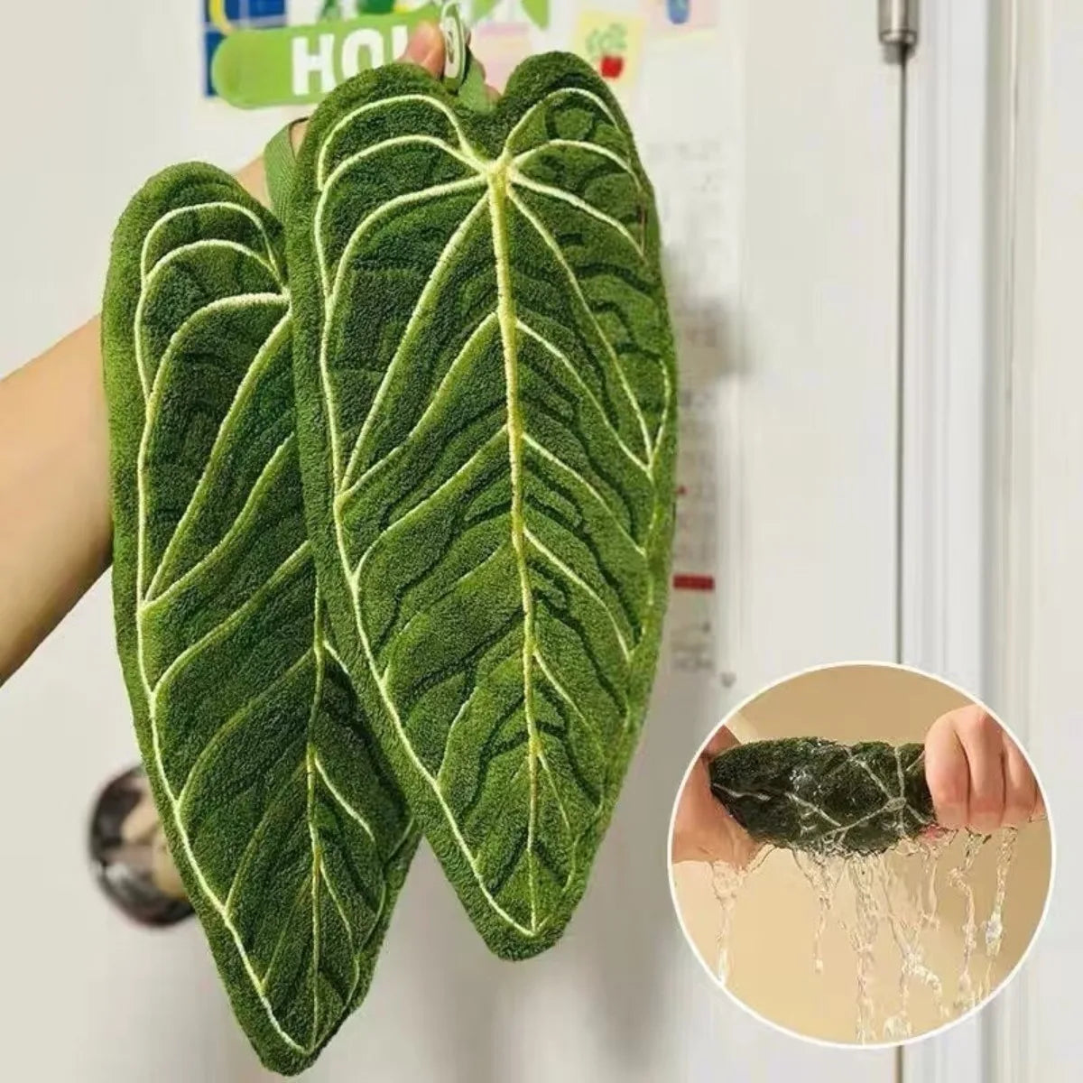 Green artificial leaf design hand towel hanging on a wall