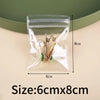 Clear plastic jewelry storage bag containing gold-toned earrings and small jewelry items