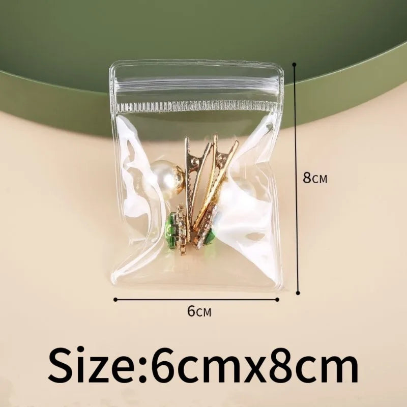 Clear plastic jewelry storage bag containing gold-toned earrings and small jewelry items