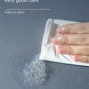 A hand is shown rubbing a white cleaning cloth on a gray floor, leaving a residue of white powder.